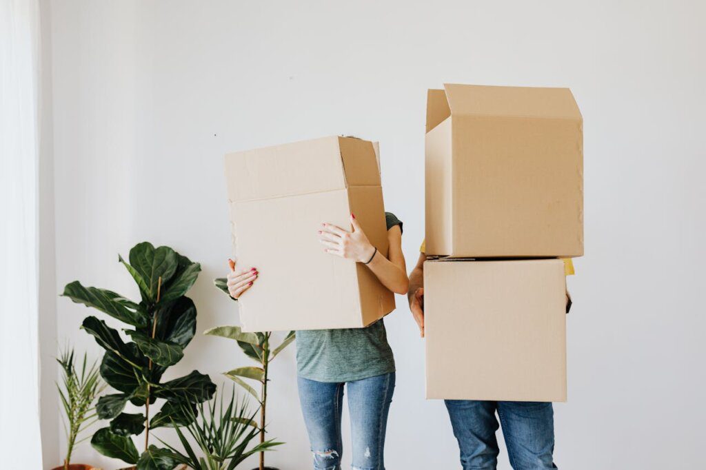 two people holding cardboard boxes