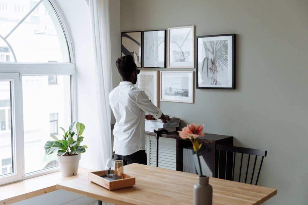 A man removing some photos from the wall in the living.